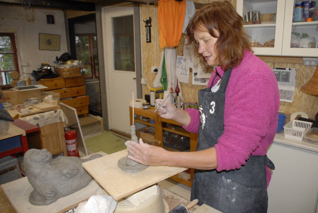 Kati Vaajasaari työstämässä keramiikkaveistosta työpajallaan.