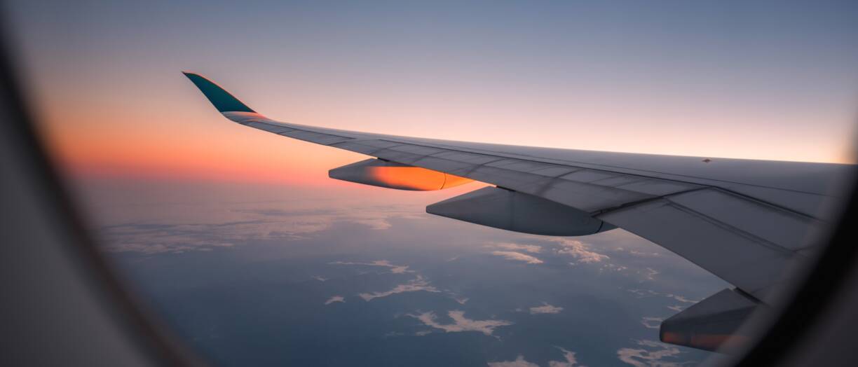 valokuva lentokoneen ikkunasta. Kuvassa näkyy lentokoneen siipi.