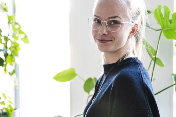 Kuvassa psykologian opettaja Kati Pouttu katsoo kameraan kahvikuppi kädessään.