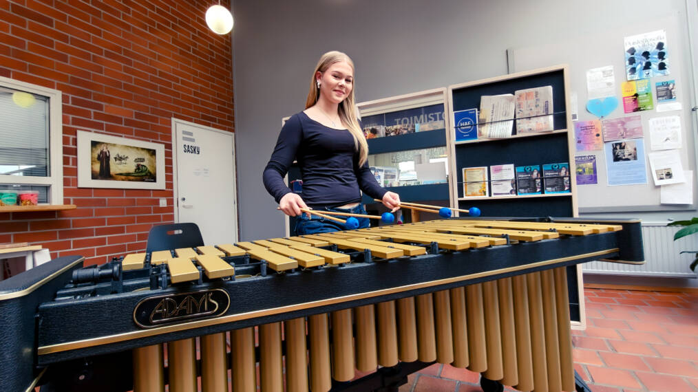 Nuori henkilö soittaa vibrafonia aulatilassa