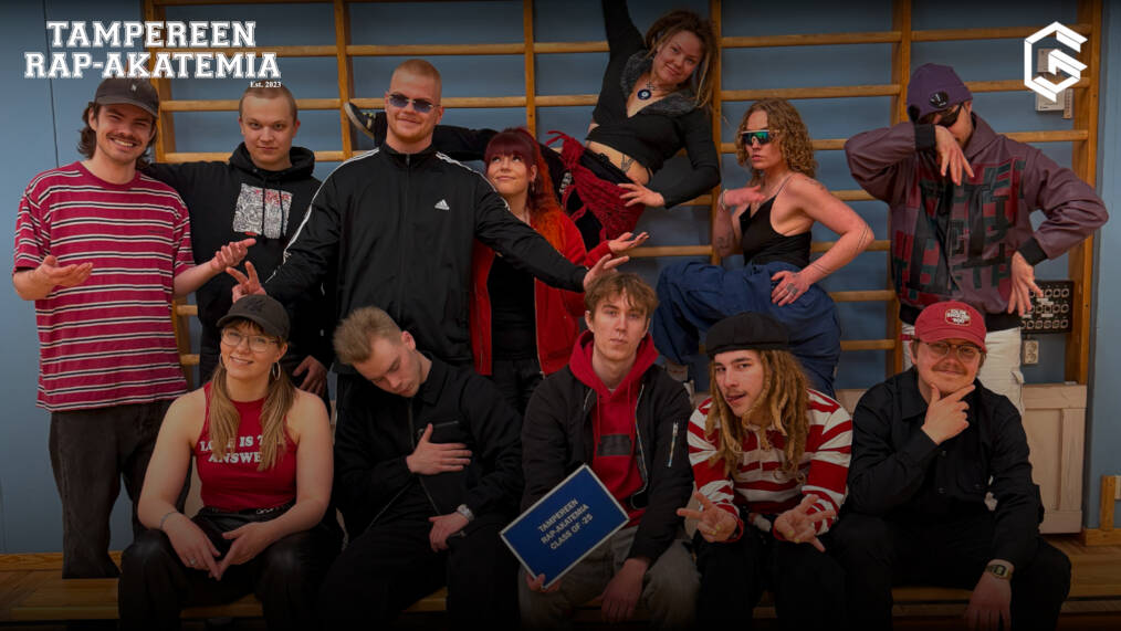 Kuvassa joukko nuoria henkilöitä. Taustalla puolapuut ja etummaisella henkilöllä kädessään kyltti, jossa lukee "Tampereen rap-akatemia class of 25".