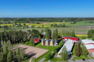 Ilmakuva kesäisestä maalaismaisemasta, keskellä kuvaa näkyy Saskyn Osaran toimipisteen rakennuksia.